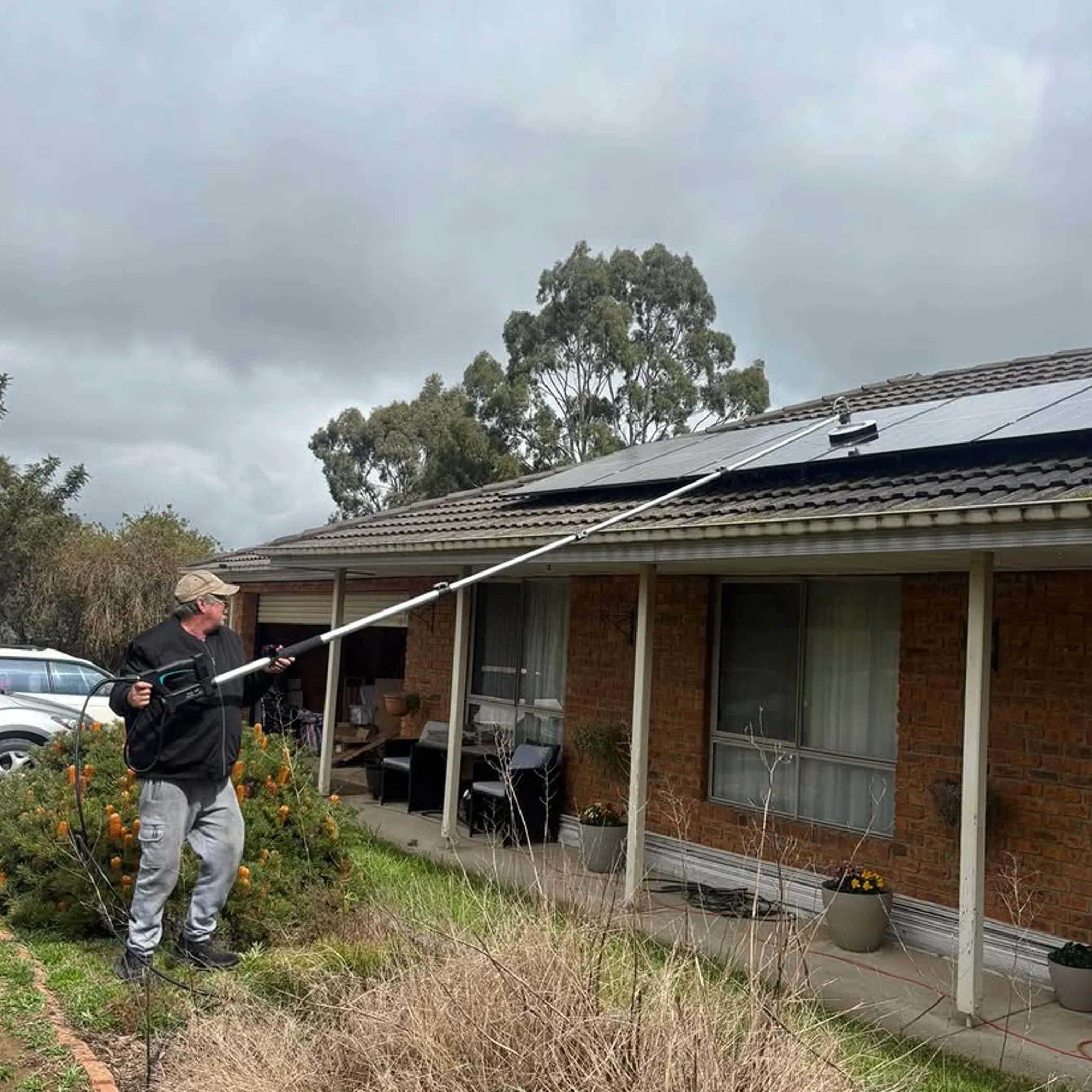 person cleaning rooftop solar panels